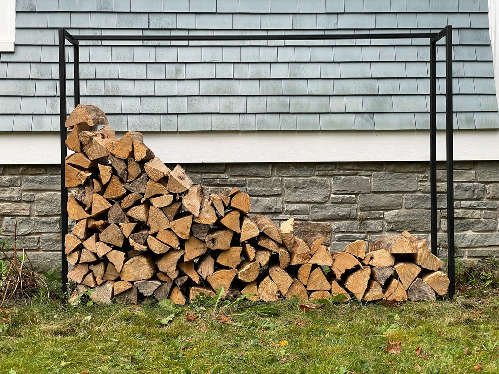 Modern black firewood rack with stacked firewood
